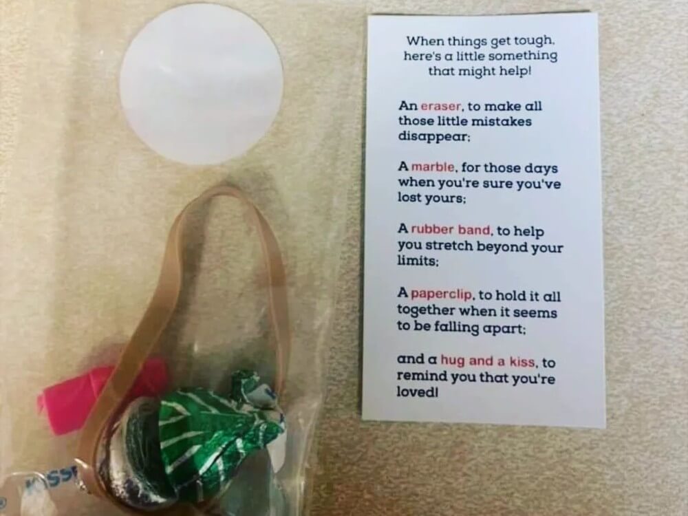 Bag with a pencil eraser, a rubber band, a marble, and two chocolates with an attached note that reads - When things get tough, here's a little something that might help!